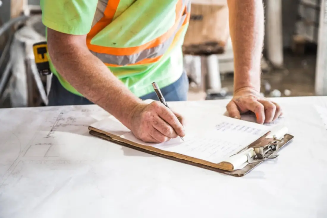 Engineer marking up drawings on a clipboard