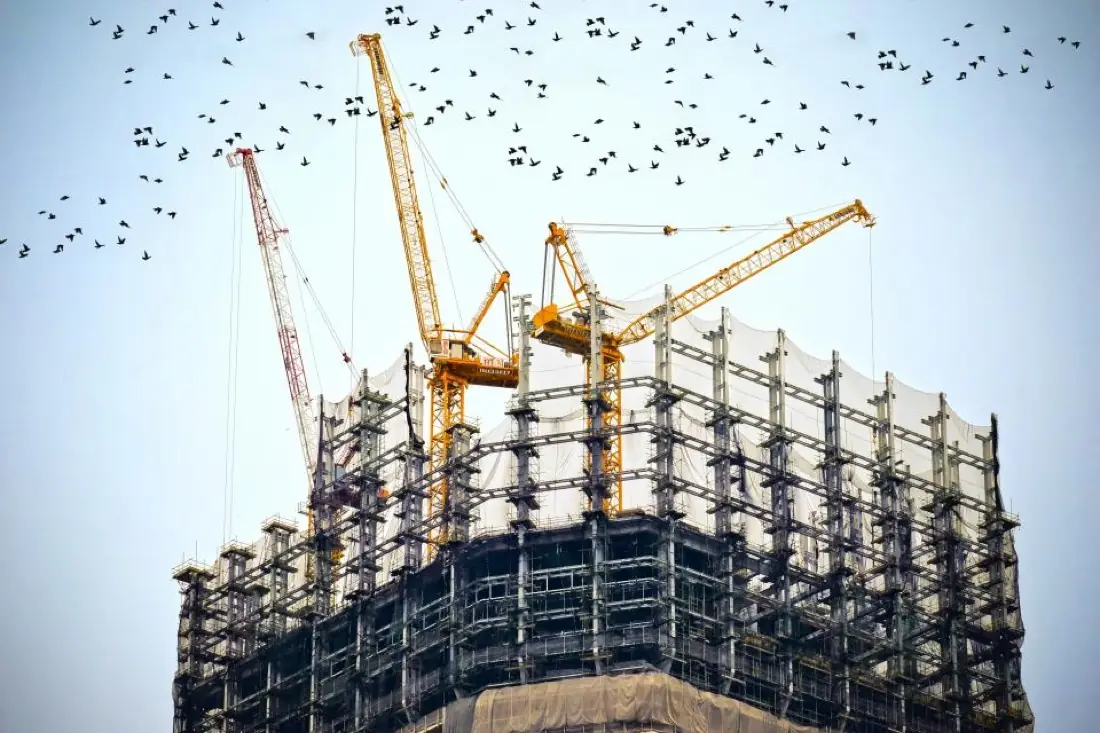 High-rise building under construction with tower cranes