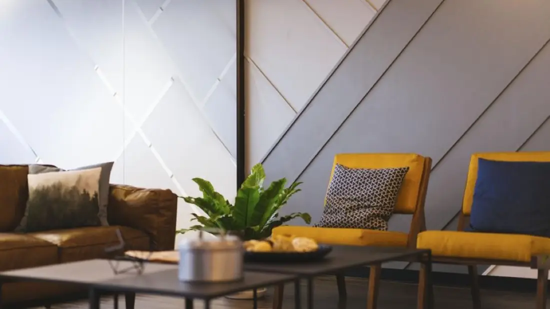 Modern interior lounge with yellow chairs and plants