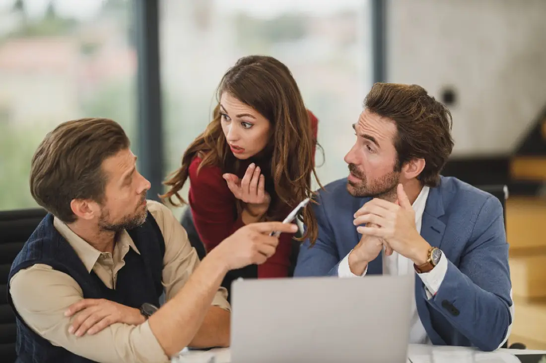 Mentor reviewing work with two young professionals