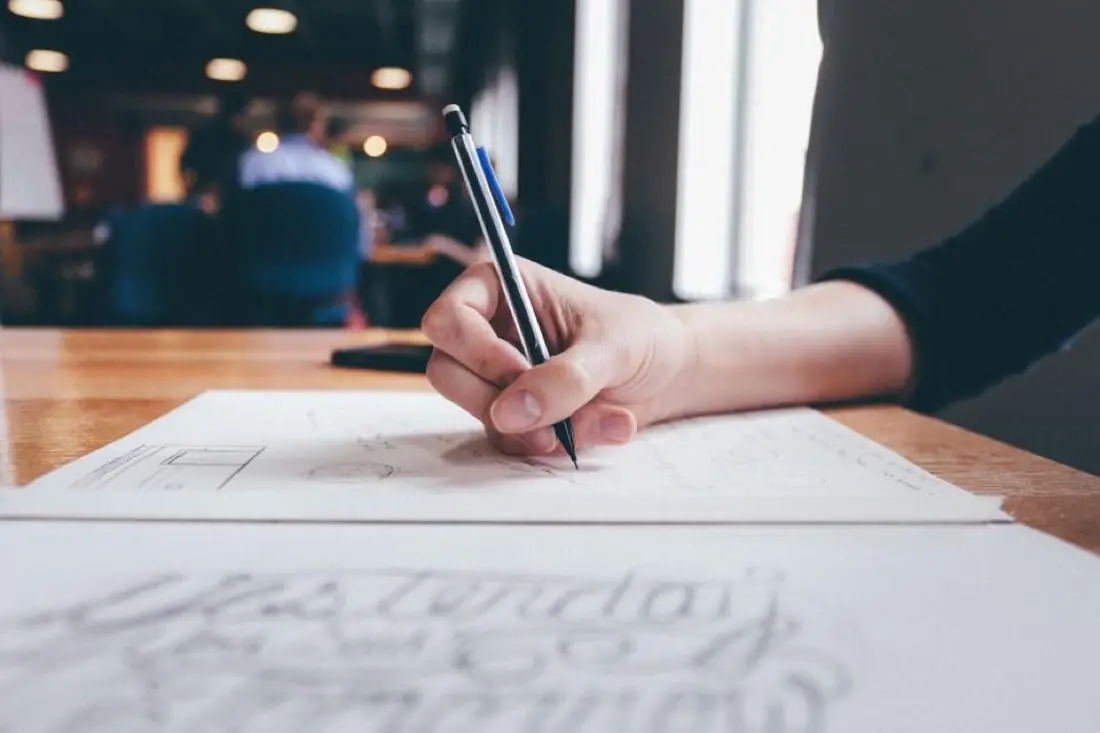 Designer sketching on paper with a pen